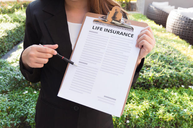 Midsection Of Female Agent With Life Insurance Documents In Yard 