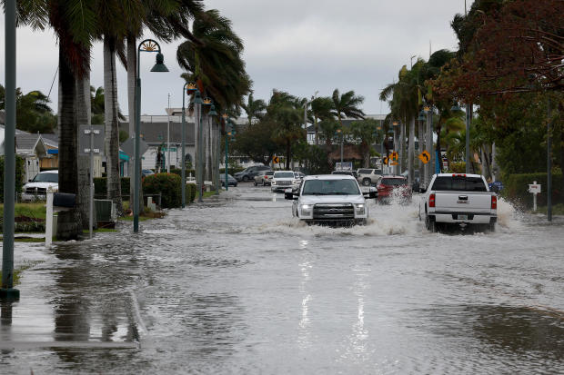 Vehicles drive through a flooded street after Hurricane Nicole came ashore on November 10, 2022, in Fort Pierce, Florida. 