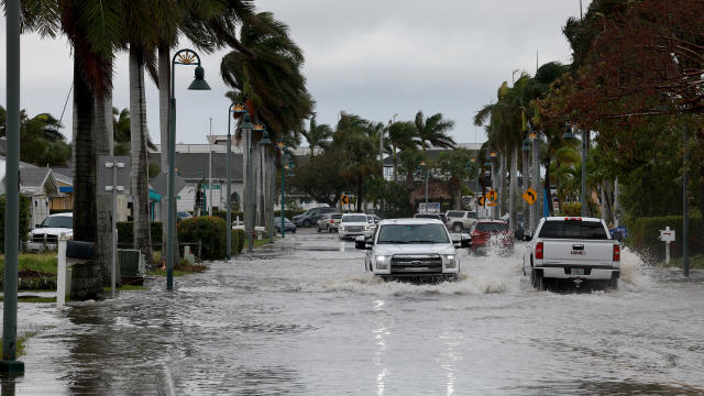 Vehicles drive through a flooded street after Hurricane Nicole came ashore on November 10, 2022, in Fort Pierce, Florida. 