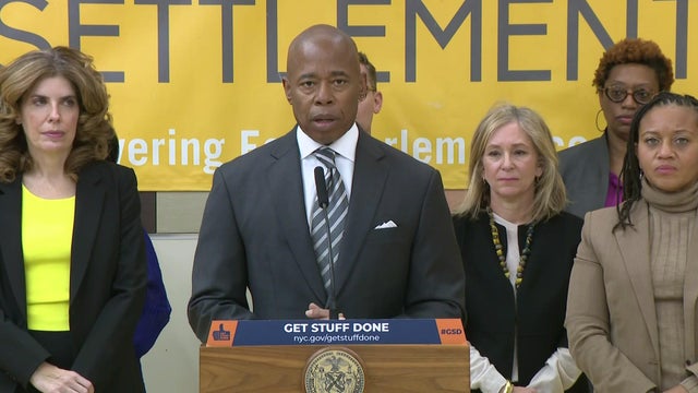 Mayor Eric Adams stands behind a podium. 