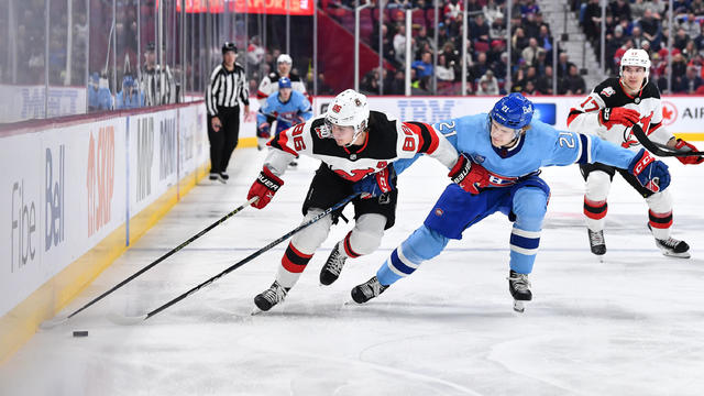Jack Hughes #86 of the New Jersey Devils skates the puck against Kaiden Guhle #21 of the Montreal Canadiens during the first period of the game at Centre Bell on November 15, 2022 in Montreal, Quebec, Canada. 