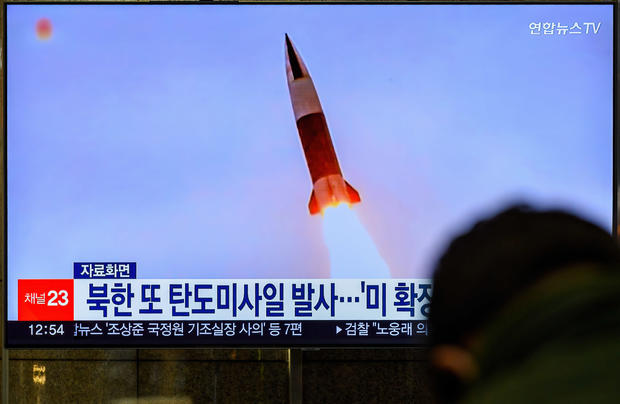 A TV screen shows a file image of North Korea's missile 