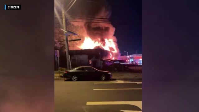 Flames and smoke billow from a gas station. 