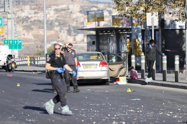 Israeli police officers conduct an investigation following an explosion near a bus stop that left at least seven people injured in West Jerusalem