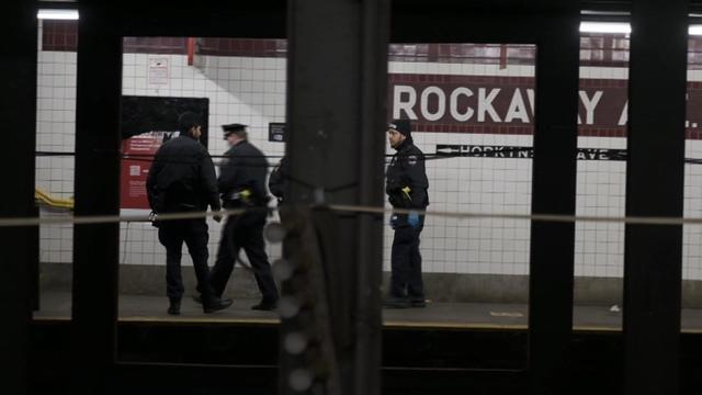 Police officers stand on the platform at the Rockaway Avenue subway station. 