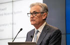 Fed Chair Jerome Powell in front of PowerPoint presentation 