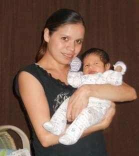 Christy Woodenthigh holds a baby 