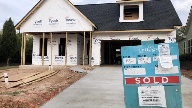 Home under construction with "sold" sign in front 