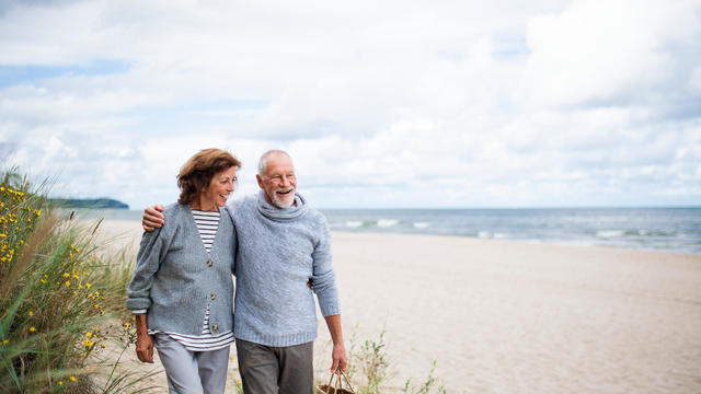 Senior couple in love on walk on beach. 