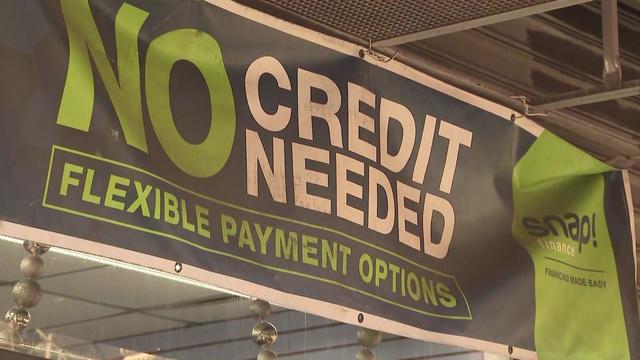 A banner in a store advertises flexible payment options, saying "No credit needed." 