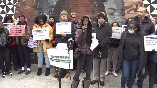 People at a rally hold up signs reading, "YouthJusticeNY." 