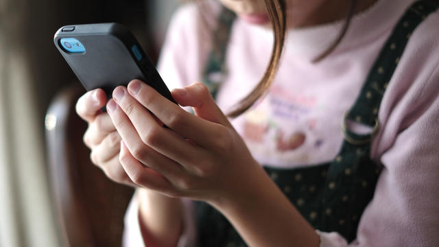 Kid looking at smartphone 