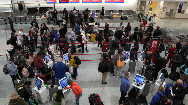 People wait in a TSA screening line at Orlando International 