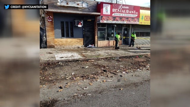 Dirt and debris lies against a curb and on a sidewalk where an outdoor dining structure once stood. 