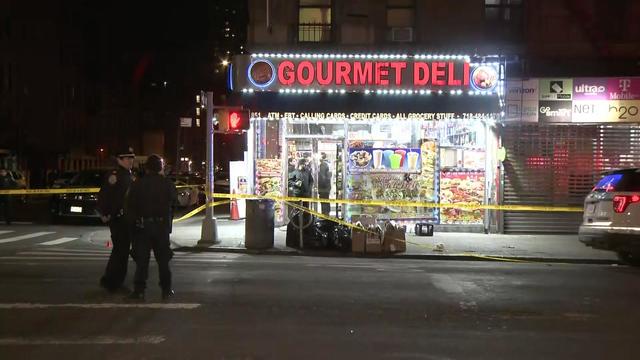 NYPD officers stand outside a deli in the Bronx. 