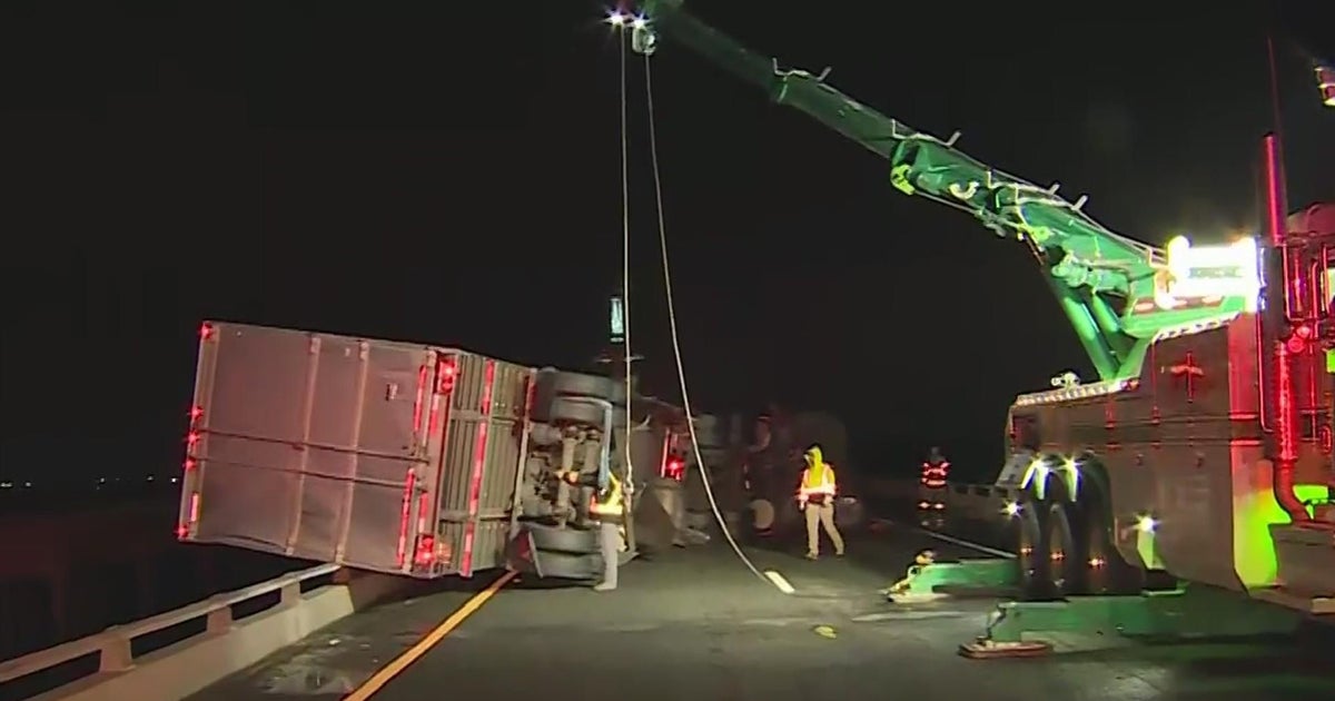 Winds blow over big rig, leaving it partially hanging over Yolo Bypass