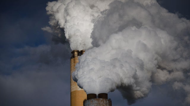 Steam billows out of the stacks at a coal-fired power plant