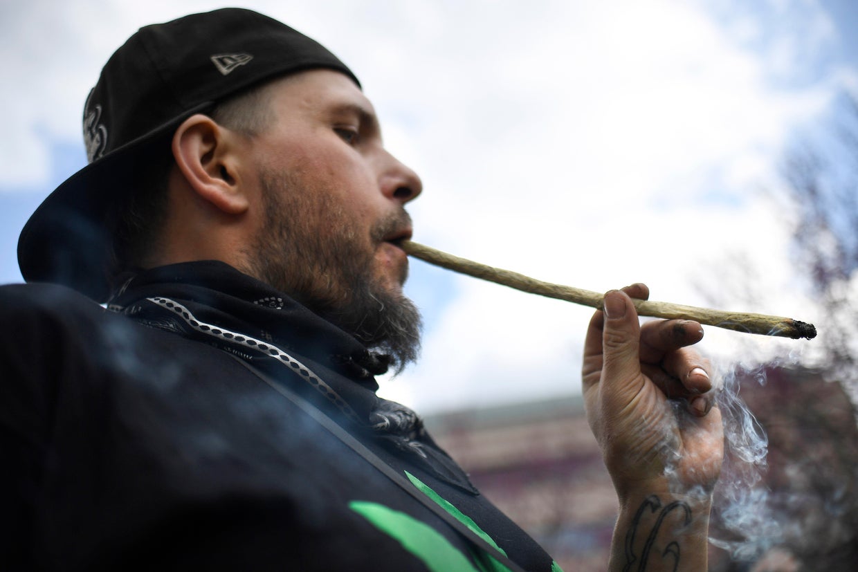 Joshua Frazer smokes a marijuana cigarette outside the Legislative Office Building during a rally April 20, 2021, in Hartford, Conn. 