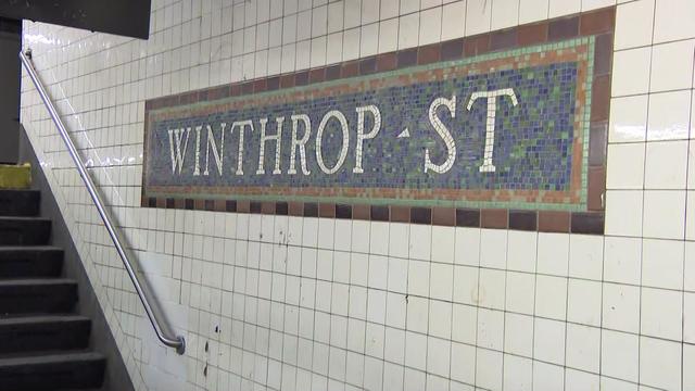 A sign for the Winthrop Street subway station on the station platform. 