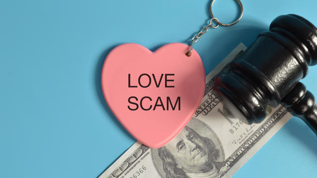 Top view of judge gavel, money banknote and love shape written with LOVE SCAM. 