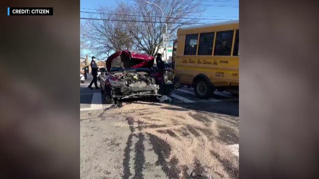 A vehicle with severe front end damage sits next to a mini school bus. 