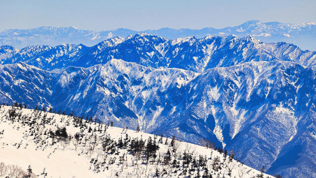 The snow-capped peaks of Joshinetsu seen from Mt. Hakuba-Norikura in the Japan Alps 