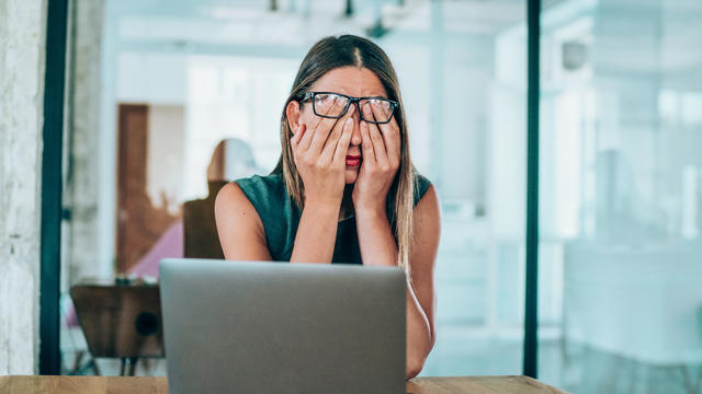 Female entrepreneur with headache sitting at desk 