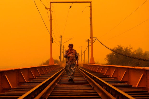 A woman walks on a bridge during the fires in Renaico, Araucania region, Chile