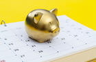 Calendar and piggy bank on yellow background 