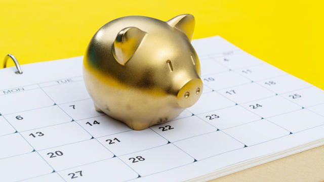 Calendar and piggy bank on yellow background 