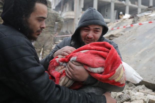 A Syrian man weeps as he carries the body of his son who was killed in an earthquake in the town of Jandaris, in the countryside of Syria's northwestern city of Afrin in the rebel-held part of Aleppo province, on February 6, 2023. 
