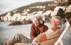 Happy couple relaxing on chairs at beach 