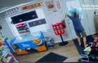 A woman wearing shorts and a long-sleeved shirt with no shoes on holds a gas station door closed. 