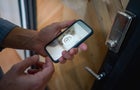 Man opening the door of his house using a home automation system 