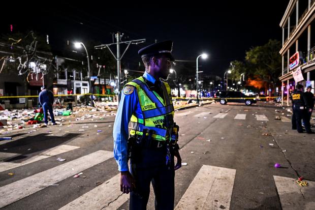 Police officers work at the scene of a shooting that occurred during the Krewe of Bacchus parade in New Orleans, February 19, 2023. 