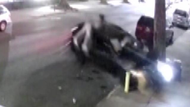 A man hangs onto the roof of a vehicle as it crashes into a fire hydrant. 