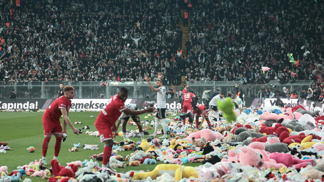 Fans throw toys on the soccer pitch for children affected by earthquake during a match, in Istanbul 