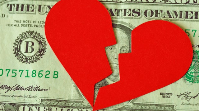 Broken heart on dollar banknote - Concept of love and money relationship 