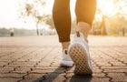 Runner feet running on road closeup on shoe. 