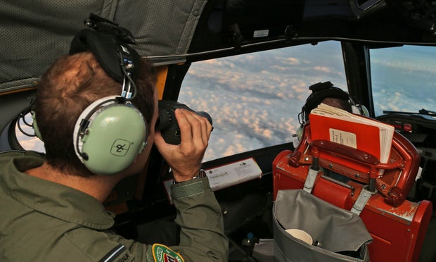 Crew on board a Royal Australian Air Force AP-3C Orion scan ahead as they search for missing Malaysian Airlines flight MH370 debris or wreckage on March 22, 2014, in the Southern Indian Ocean, off the west coast of Australia