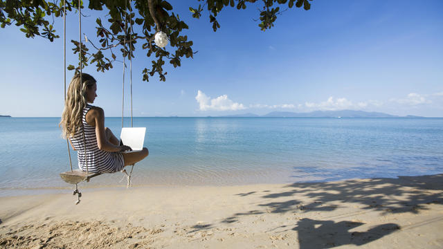 Thailand, woman using laptop on beach 