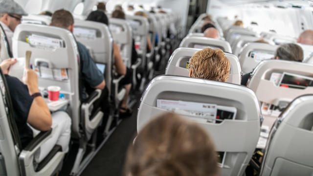 Interior of commercial airplane with passengers in their seats 