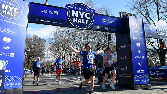 Runners celebrate as they cross the finish line during the 2022 United Airlines NYC Half Marathon on March 20, 2022 in New York City. 