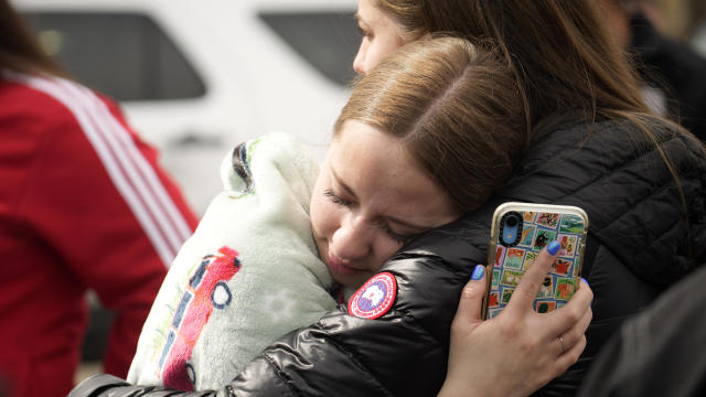 Two women hug following a shooting at Denver's East High School on March 22, 2023. 