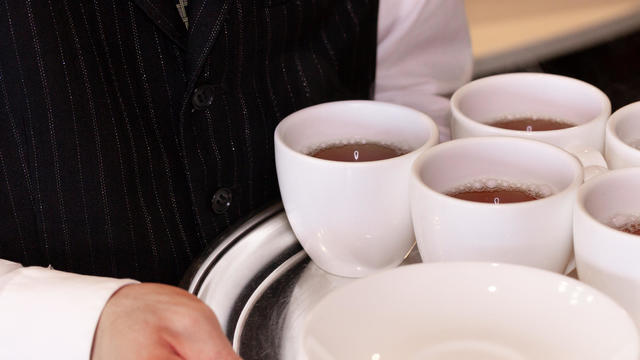 Waiter serving hot drinks on a tray 