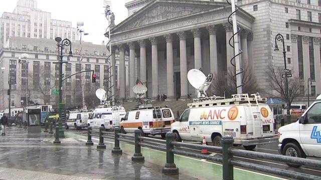 Fake news vans from the movie "Joker: Folie à Deux" sit parked outside a Manhattan courthouse as crews prepare to film. 