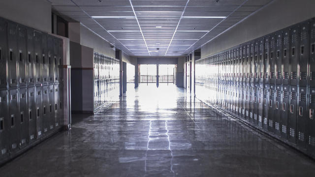 Empty high school corridor with lockers lining the walls 