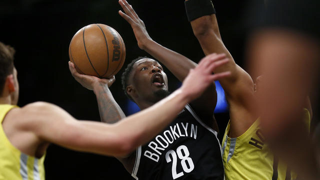 Brooklyn Nets forward Dorian Finney-Smith (28) puts up a shot while being defended by Utah Jazz players during the first half of an NBA basketball game Sunday, April 2, 2023, in New York. 