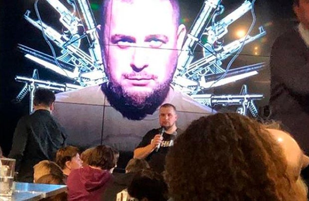 Russian military blogger Vladlen Tatarsky speaks during a party in front of projection of an image of himself at a cafe in St. Petersburg, Russia, April 2, 2023, before an explosion that killed him and left more than a dozen other people wounded