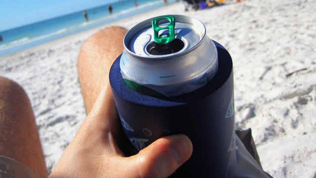 Man Drinking a Can of Beer at the Beach 